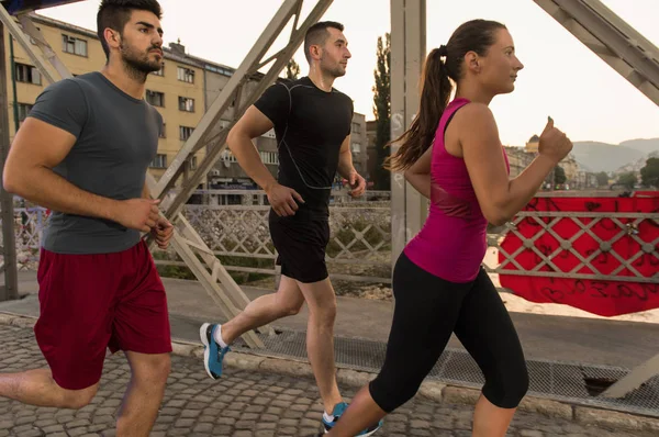 group of young people jogging across the bridge