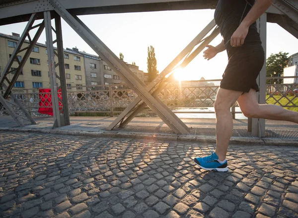 Człowiek, jogging przez most w słoneczny poranek — Zdjęcie stockowe