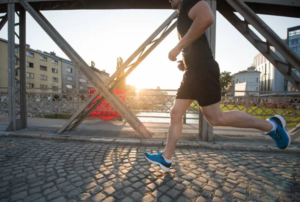 Muž běhat přes most na slunečné ráno — Stock fotografie