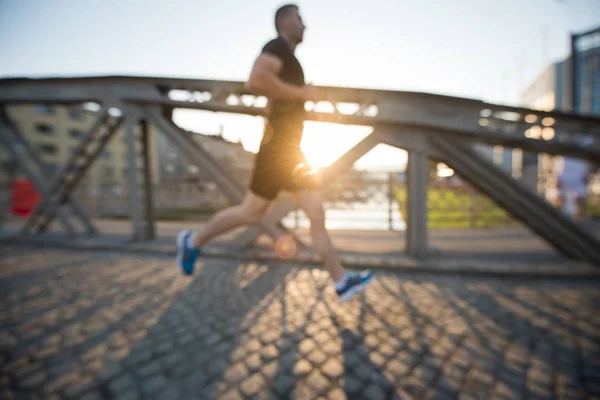 Man joggen over de brug op zonnige ochtend — Stockfoto