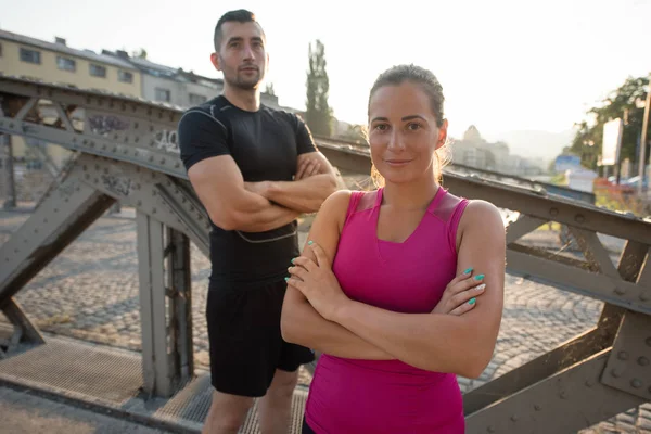 Jovem casal correndo através da ponte na cidade — Fotografia de Stock