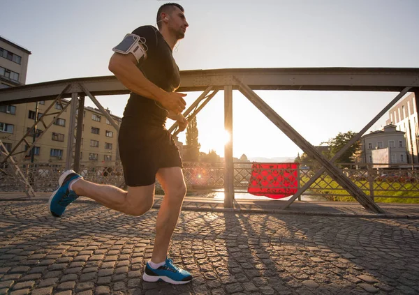 Muž běhat přes most na slunečné ráno — Stock fotografie