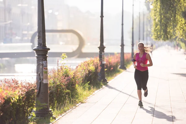 Kobieta, jogging w słoneczny poranek — Zdjęcie stockowe