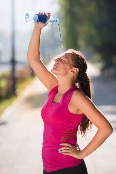 Frau schüttet sich Wasser aus Flasche auf den Kopf — Stockfoto