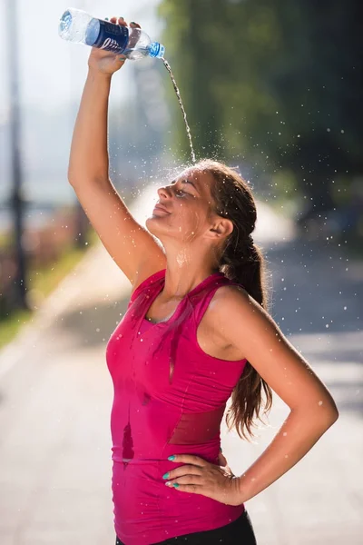 Kobieta, wylewanie wody z butelki na głowę — Zdjęcie stockowe