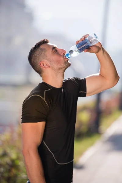 Hombre beber agua de una botella después de correr — Foto de Stock