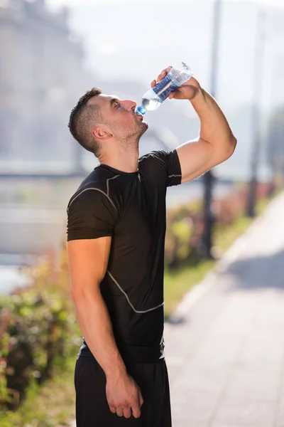 Mann trinkt nach Joggen Wasser aus Flasche — Stockfoto