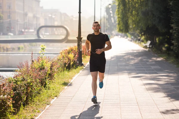 Hombre corriendo en la soleada mañana — Foto de Stock