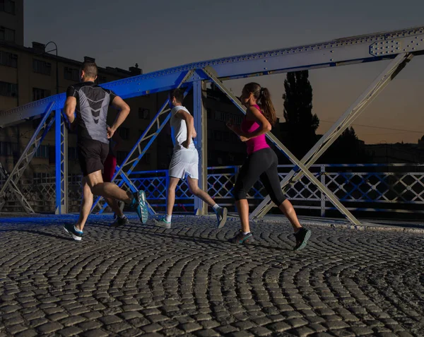 Jeunes gens jogging à travers le pont — Photo