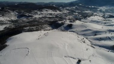 Kış orman ağaçları güneşli hava üstten görünüm 4k üzerinde uçan. Kar kapak vahşi ormanda kirişler parlayan güneş ışığı ile yukarıda hava uçuş