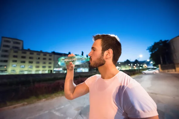 Jovem Atlético Homem Água Potável Depois Uma Noite Correndo Sessão — Fotografia de Stock