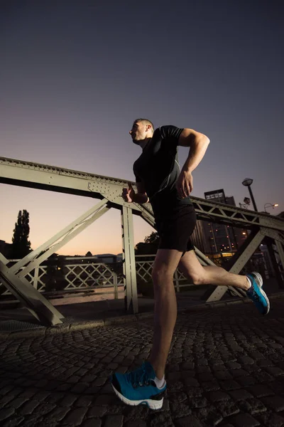 都市スポーツ 市内の橋を渡って早朝ジョギング若い健康な男 — ストック写真