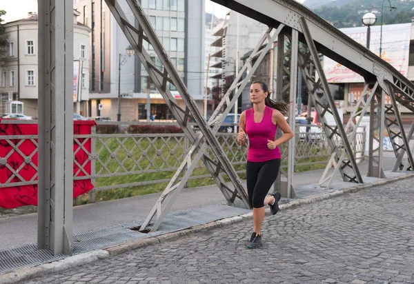 Młoda Kobieta Sportowy Jogging Przez Most Słoneczny Poranek Mieście — Zdjęcie stockowe