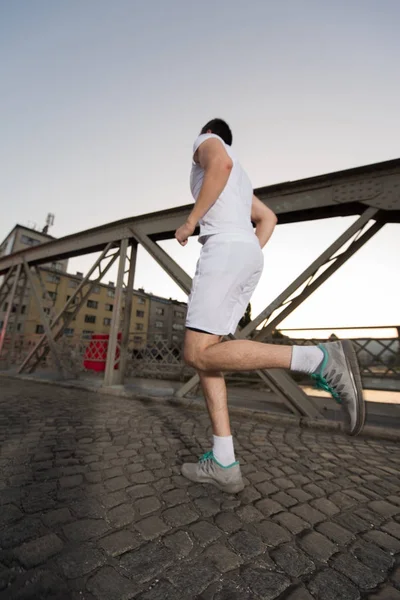 Sportieve Jongeman Joggen Brug Zonnige Ochtend Stad — Stockfoto