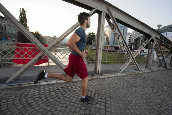 Mladý Sportovní Jogging Přes Most Slunečné Ráno Městě — Stock fotografie