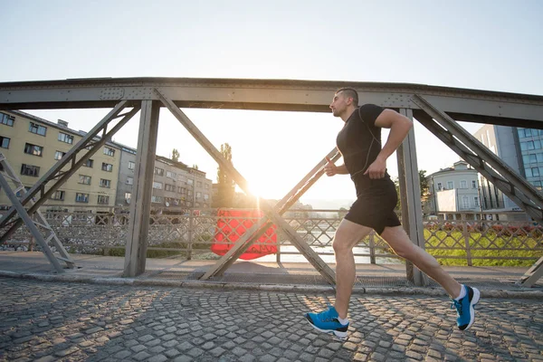 Giovane Sportivo Che Corre Attraverso Ponte Mattino Sole Città — Foto Stock