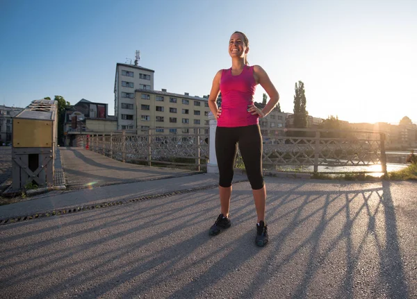 在阳光明媚的早晨在城市的一个年轻运动的慢跑妇女的画像 — 图库照片