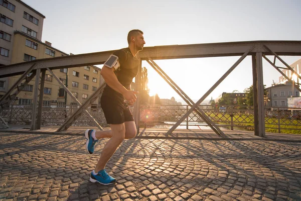 Mladý Sportovní Jogging Přes Most Slunečné Ráno Městě — Stock fotografie