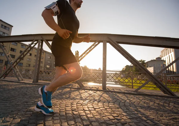 Młody Człowiek Sportowy Jogging Przez Most Słoneczny Poranek Mieście — Zdjęcie stockowe
