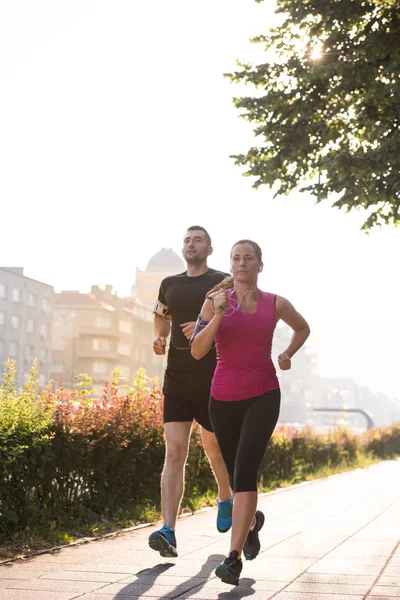 都市スポーツ 晴れた朝に市内でジョギング健康な若いカップル — ストック写真