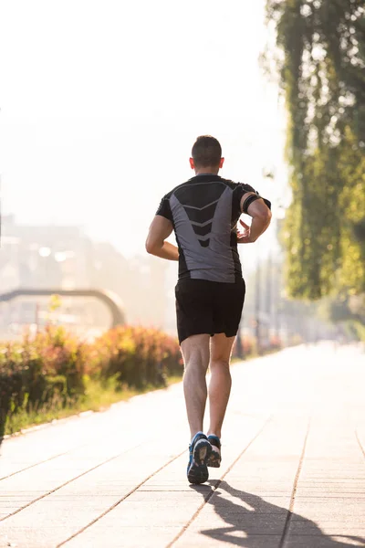 Młody Człowiek Sportowy Jogging Słoneczny Poranek Mieście — Zdjęcie stockowe