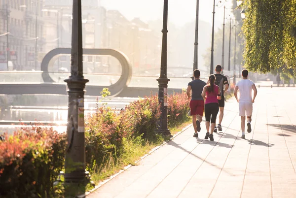 Grupo Jovens Desportistas Jogging Manhã Ensolarada Cidade — Fotografia de Stock