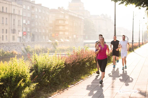 Grupo Jovens Desportistas Jogging Manhã Ensolarada Cidade — Fotografia de Stock