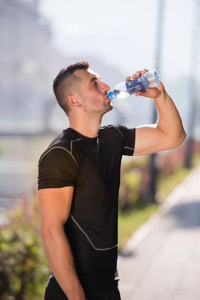 Αθλητής Άνθρωπος Πόσιμο Νερό Από Ένα Μπουκάλι Μετά Από Τρέξιμο — Φωτογραφία Αρχείου