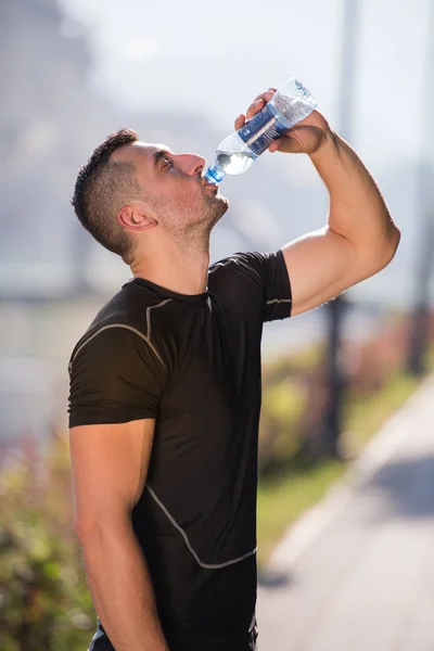 Αθλητής Άνθρωπος Πόσιμο Νερό Από Ένα Μπουκάλι Μετά Από Τρέξιμο — Φωτογραφία Αρχείου