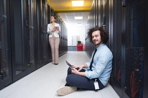 Ung tekniker arbetar tillsammans på servrar — Stockfoto