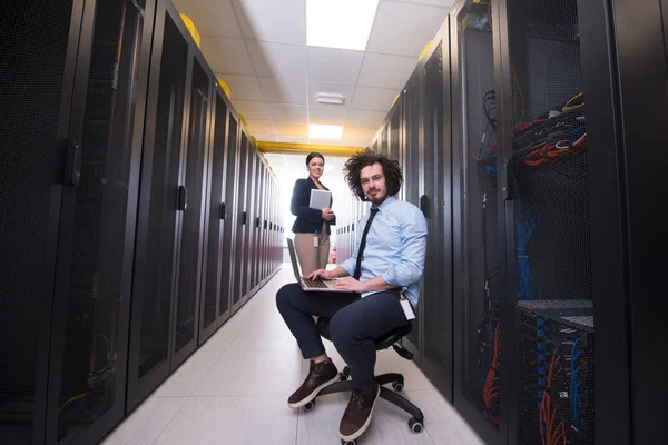 Equipe de jovens técnicos trabalhando juntos em servidores — Fotografia de Stock