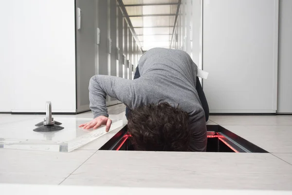 Ingénieur connectant les câbles dans la salle des serveurs — Photo