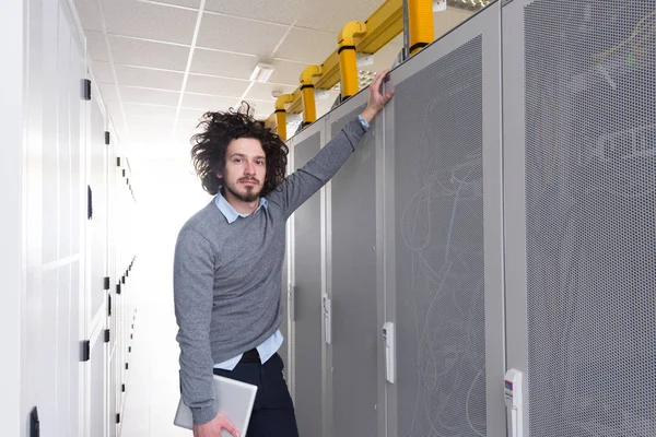 Ingeniero informático que trabaja en una tableta en la sala de servidores —  Fotos de Stock