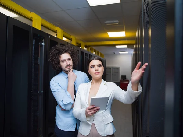 Інженер, що показує робочу кімнату сервера даних головній жінці — стокове фото