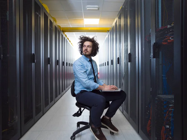 Engenheiro trabalhando em um laptop na sala do servidor — Fotografia de Stock