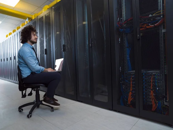 Ingeniero que trabaja en una computadora portátil en la sala de servidores — Foto de Stock