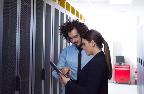 engineer showing working data center server room to female chief