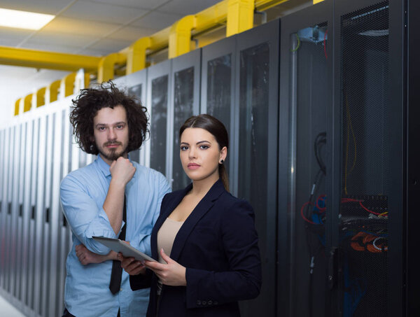 engineer showing working data center server room to female chief