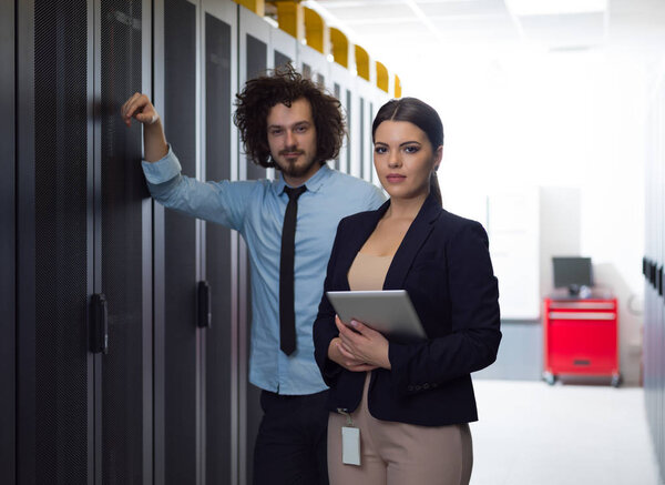 engineer showing working data center server room to female chief