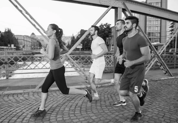 Grupo Jóvenes Deportistas Corriendo Través Del Puente Soleada Mañana Ciudad —  Fotos de Stock