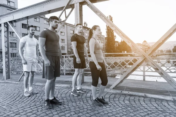 Skupina Mladých Sportovců Jogging Přes Most Slunné Ráno Městě — Stock fotografie