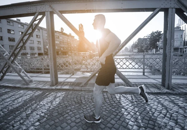 Sportieve Jongeman Joggen Brug Zonnige Ochtend Stad — Stockfoto