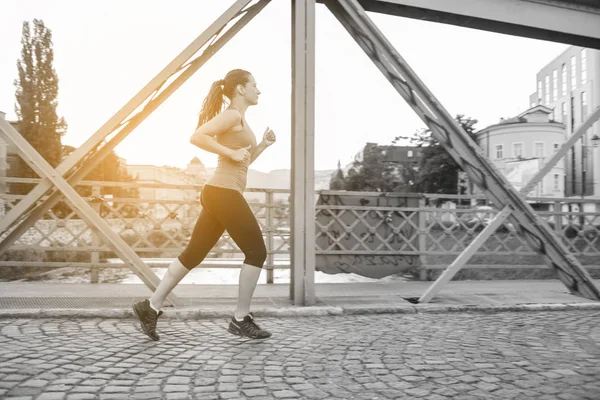 Jovem Mulher Esportiva Correndo Através Ponte Manhã Ensolarada Cidade — Fotografia de Stock