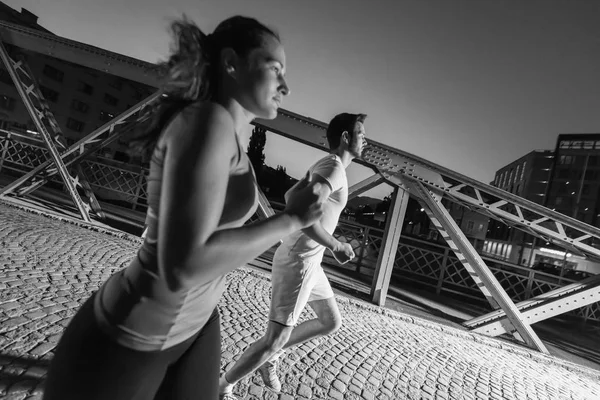 城市体育 健康的情侣在城市的桥上慢跑 在晚上的清晨 — 图库照片