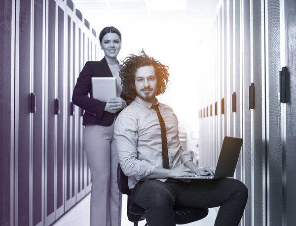 engineer showing working data center server room to female chief