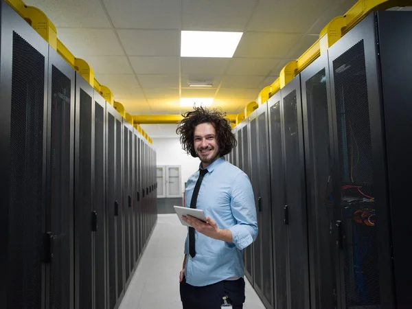 Male IT engineer working on a tablet computer in server room at modern data center