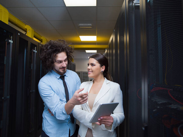 engineer showing working data center server room to female chief