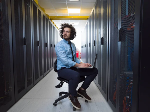 Engenheiro trabalhando em um laptop na sala do servidor — Fotografia de Stock