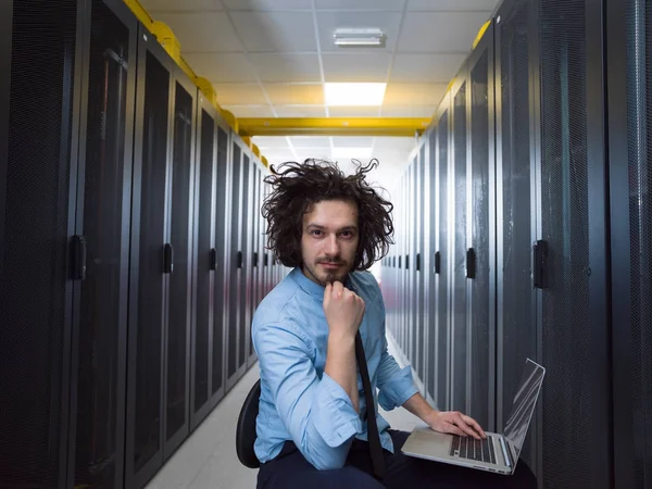 Engenheiro trabalhando em um laptop na sala do servidor — Fotografia de Stock