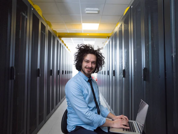 Engenheiro trabalhando em um laptop na sala do servidor — Fotografia de Stock
